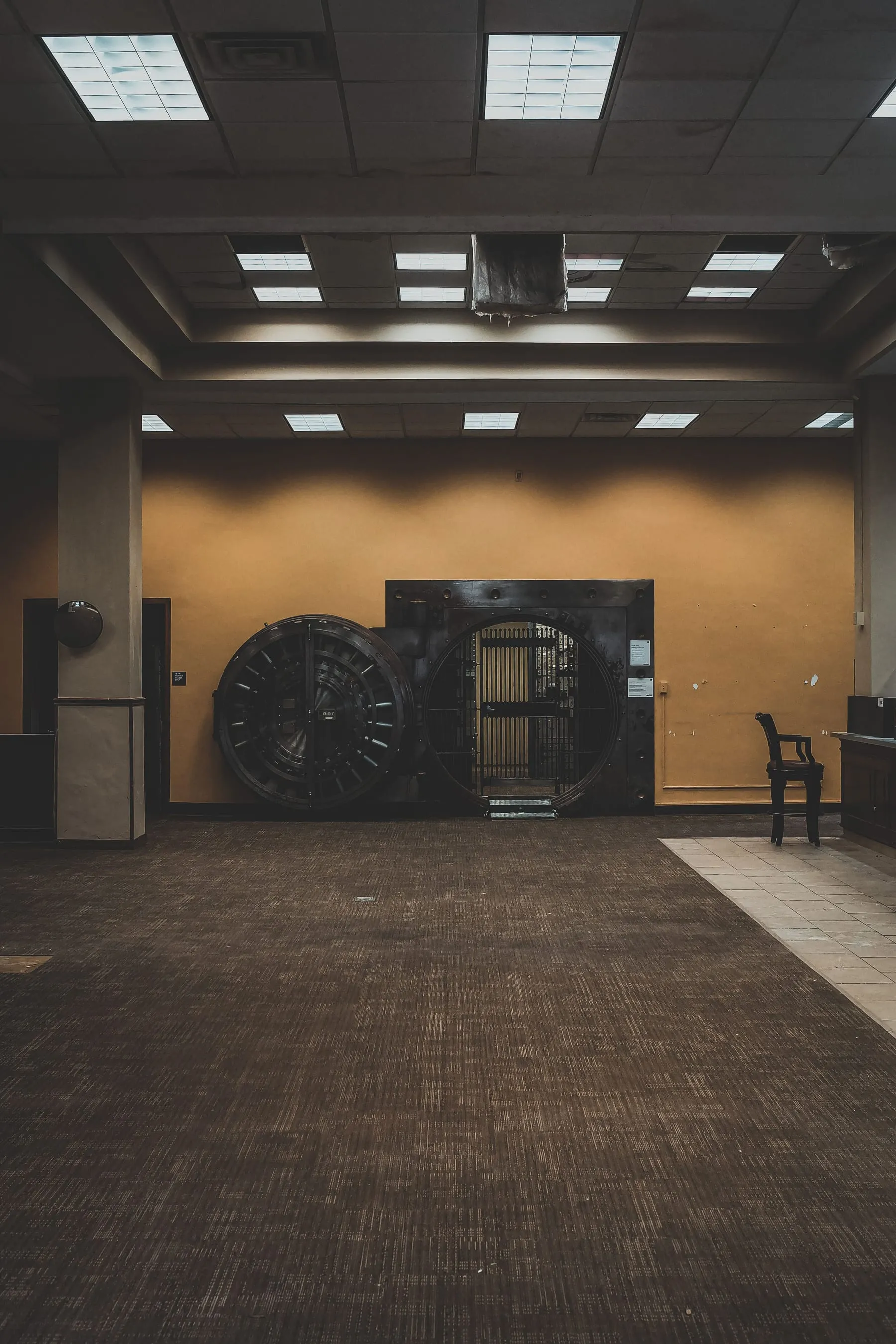 A large circular steel bank vault door, standing open.